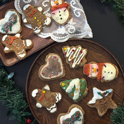 Decorative dog cookies on a wooden plate with Christmas-themed decorations.